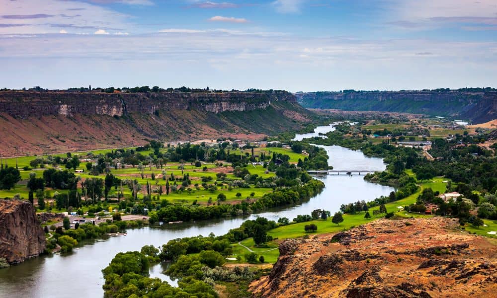 Snake River in Idaho with surrounding cliffs and farmlands highlighting environmental impacts relevant to an ALTA Land Title Survey
