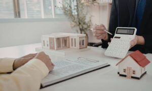 Real estate closing cost review - ALTA SURVEY Idaho Real estate buyer reviewing documents and calculator to understand ALTA survey pricing before closing