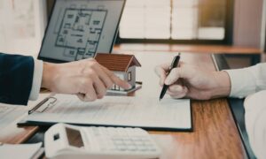 Homebuyer and agent signing documents during a real estate closing with an ALTA Title Survey review