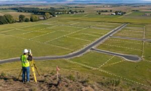 Aerial view of open land with early subdivision layout markings and planned road lines before development begins
